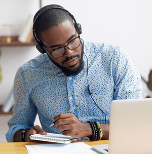 man-looking-at-computer-with-headphones
